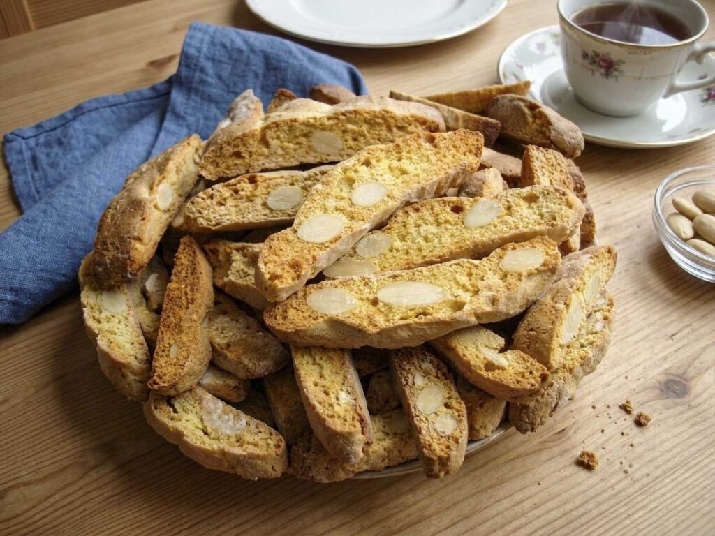 Cantucci toscani alle mandorle serviti con tè su tavola di legno