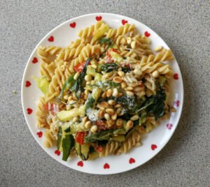 Piatto con fusilli con spinacio rampicante, zucchine e pinoli