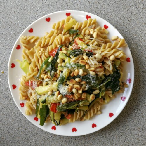 Piatto con fusilli con spinacio rampicante, zucchine e pinoli