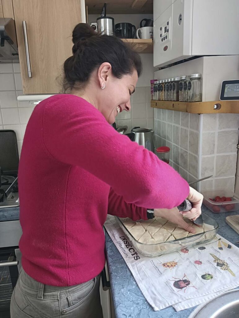 Taglio del baklava al pistacchio in teglia prima della cottura.