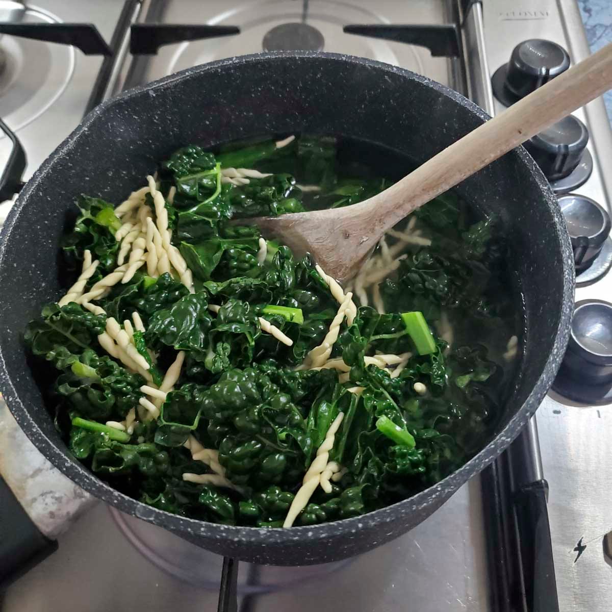 Trofie e cavolo nero che cuociono insieme in una pentola d’acqua salata