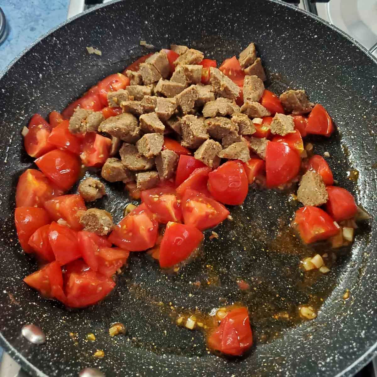 Polpette vegane aggiunte alla padella con la pasta e il condimento