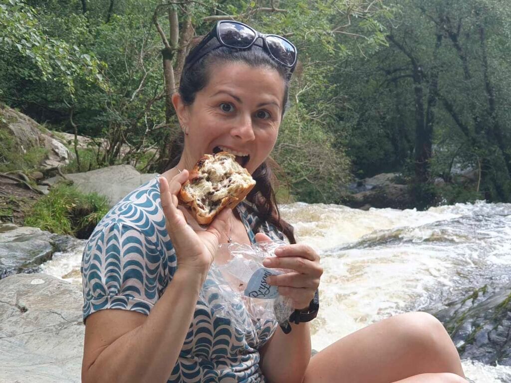 Donna mangia torta lungo un fiume