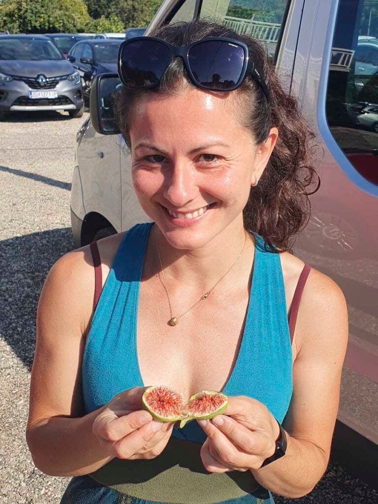 Ragazza sorridente con un fico appena raccolto in mano