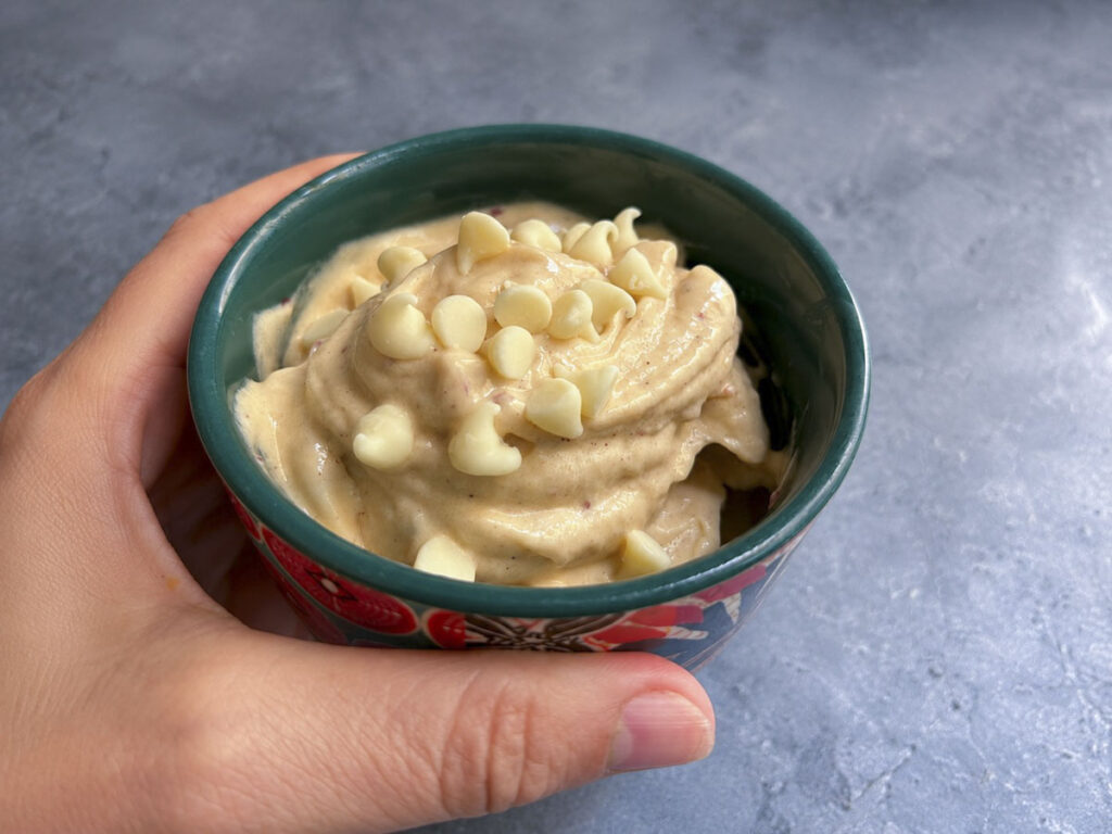Gelato fatto in casa banana e nettarina con skyr in ciotola, guarnito con gocce di cioccolato bianco.