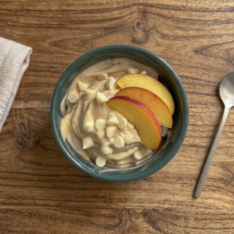 Gelato senza gelatiera fatto in casa con banana, nettarina e skyr su tavolo di legno
